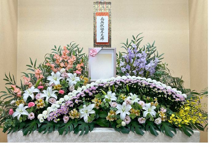 ピンクと白の生花でラインを取り写真周りにもオレンジや紫のお花があり華やかです。