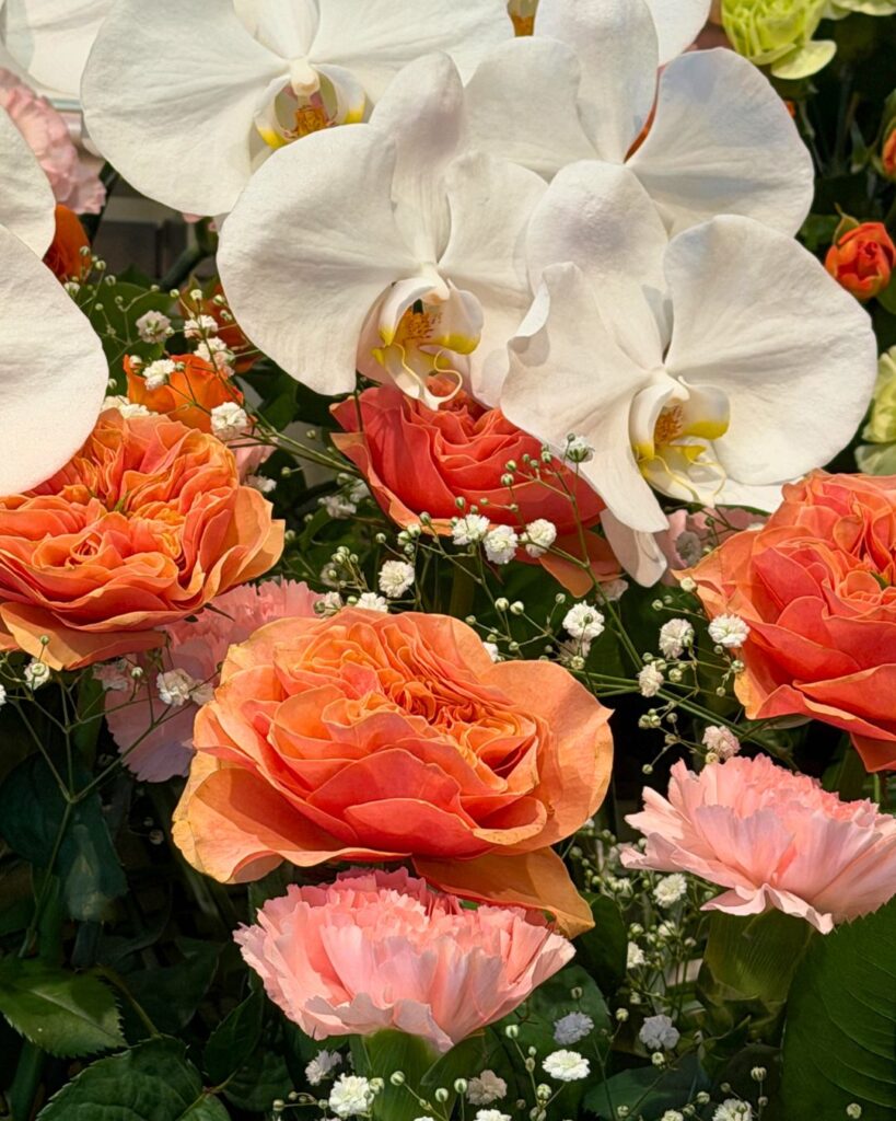 生花祭壇のアップの写真。オレンジの花が所々にあり華やかでおしゃれにする。