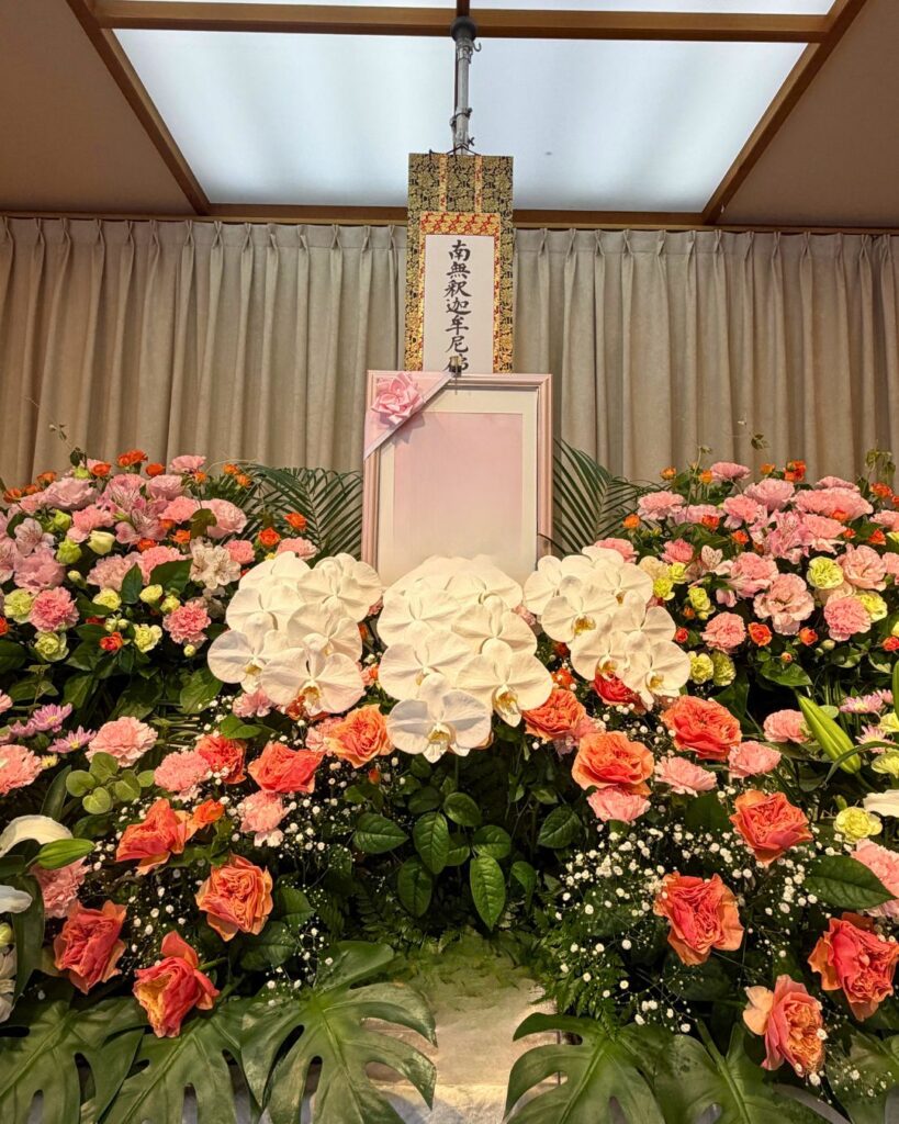 写真周りには胡蝶蘭やオレンジのミニバラなどを飾り華やかに